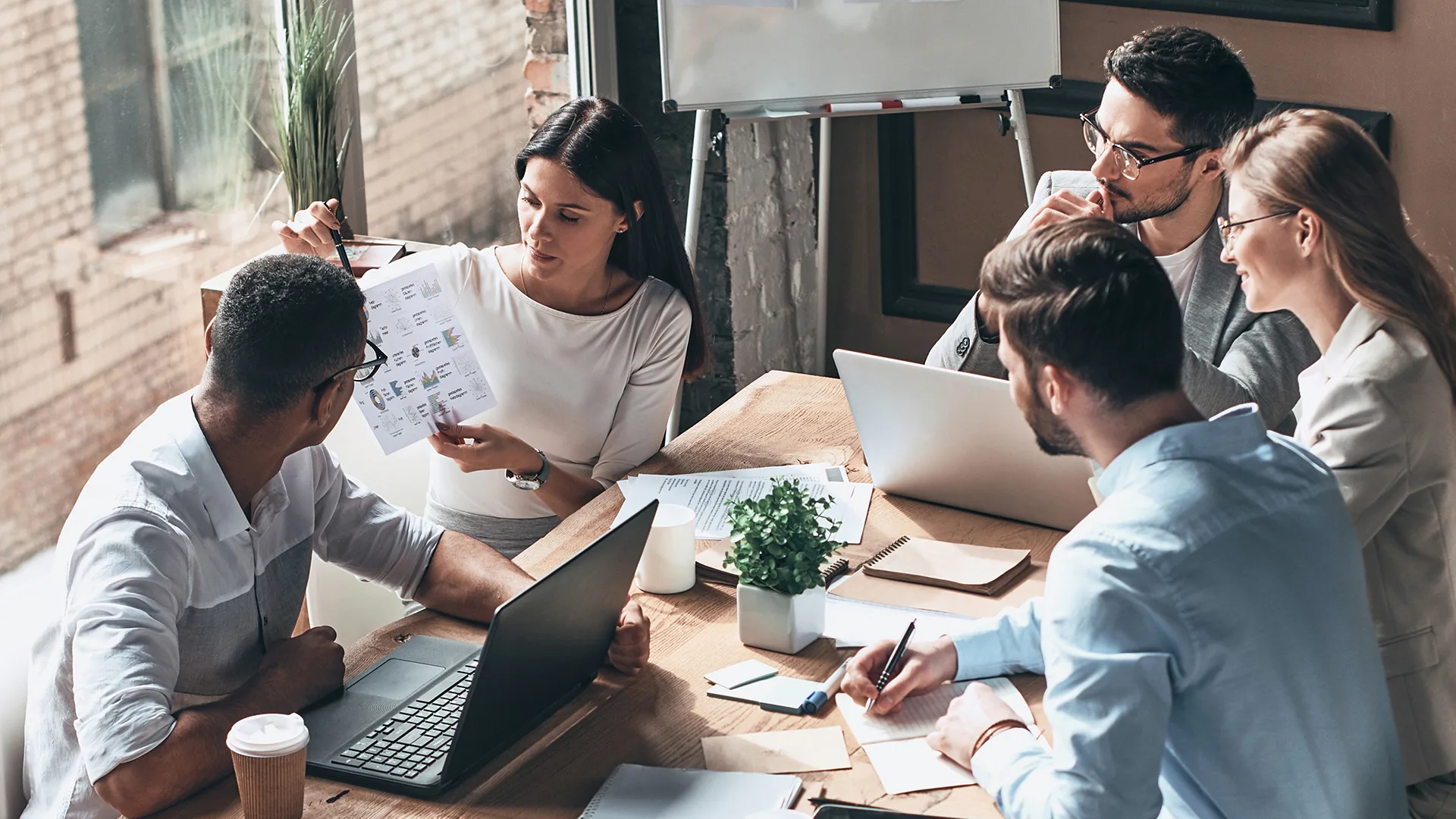 Group of young business people discussing strategy while having meeting in the office